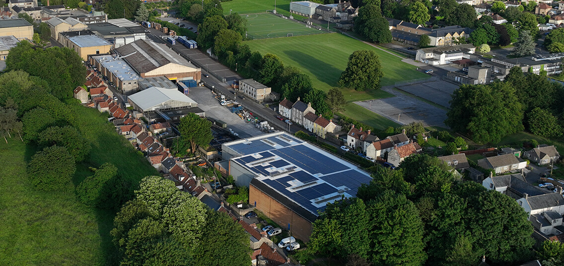 Solar panels hidden by trees on factory roof